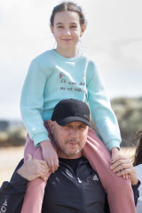 Mr Shyshko holds daughter Alisa at Parkdale beach after the family began its new life in Melbourne in late March.
