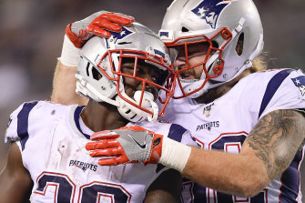 Sony Michel (left) is congratulated by Patriots teammate Eric Tomlinson after scoring one of his three touchdowns against the Jets.