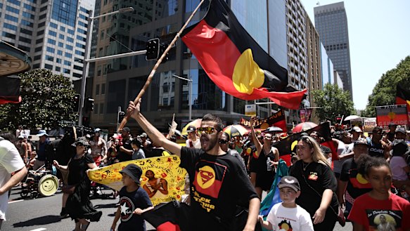 Taking to the streets:  Invasion Day Rally in Sydney on Saturday. David Dungay 's nephew Paul Dungay waves the Aboriginal flag.