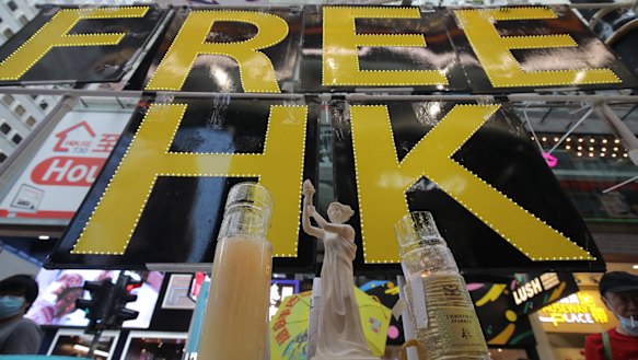 A miniature replica of the Goddess of Democracy stands in front of a 'Free HK' sign near Victoria Park.
