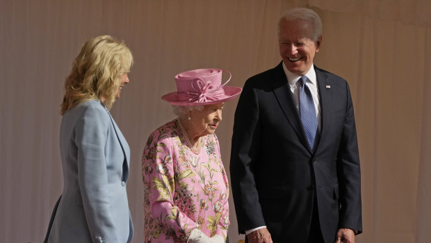 US President Joe Biden and first lady Jill Biden smile while standing with Britain’s Queen Elizabeth II watching a Guard of Honour march past before their meeting at Windsor Castle.