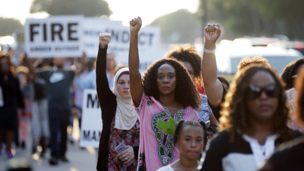 Demonstrators march around AT&T Stadium ahead of an NFL football game between the Dallas Cowboys and the New York Giants in protest of the recent killings of two black men by police, in Arlington, Texas.