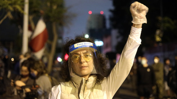 A protester wearing a protective face shield at an anti-government demonstration outside the headquarters of the Lebanese central bank in Beirut, Lebanon. 