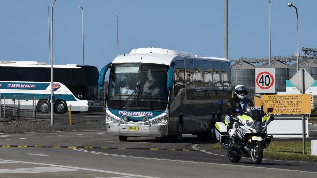 Police escort buses carrying Ruby Princess crew members as they leave Port Kembla on Tuesday.