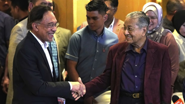 Malaysian Prime Minister Mahathir Mohamad shakes hand with his then-designated successor Anwar Ibrahim at the weekend.