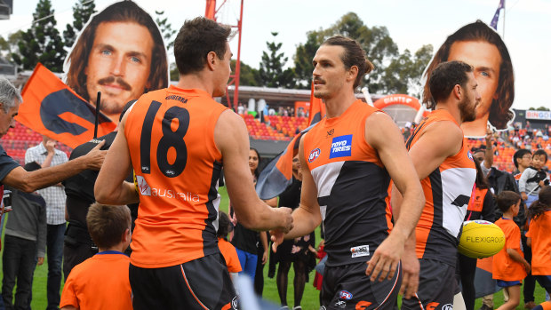 Giant step: Jeremy Cameron (left) congratulates 150th gamer Phil Davis before the game.