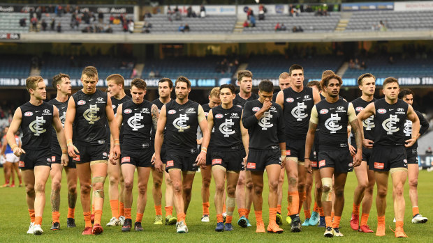 Crushing defeat: Carlton make their way from the ground after heavy loss to Melbourne.