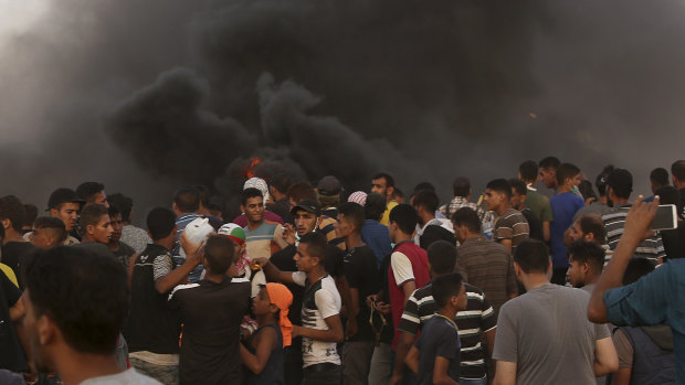 Protesters gather while burning tyres near the fence of the Gaza Strip's border with Israel on Friday.