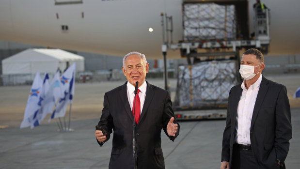 Israeli PM Benjamin Netanyahu, centre, and Health Minister Yuli Edelstein, with a shipment of Pfizer coronavirus vaccine, at Ben Gurion Airport near the city of Lod, on Sunday.