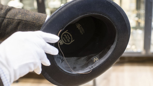 A man holds a hat with the initials of Adolf Hitler prior to an auction in  Germany.