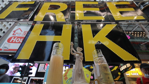 A miniature replica of the Goddess of Democracy stands in front of a 'Free HK' sign near Victoria Park.