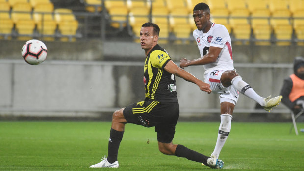 Dip and swerve: Roly Bonevacia curls the ball past Steven Taylor in appalling conditions in the New Zealand capital.