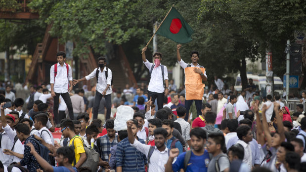 A Bangladeshi student waves the national flag and shouts slogans as they block a road during a protest in Dhaka.