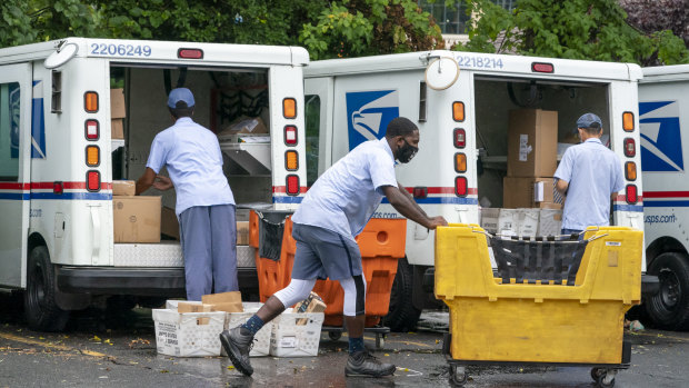 Letter carriers load mail trucks for deliveries at a US Postal Service facility in McLean, Virginia. 
