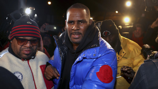 R. Kelly turns himself in at a Chicago police station after being charged with sexual abuse.