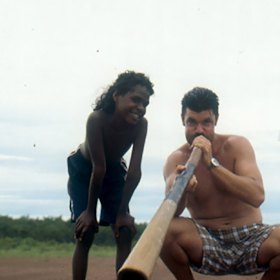 Blak Douglas and a young Yolngu chaperone on the air strip at Dhalenbuy.