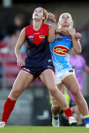 Lauren Pearce of the Demons and Charlie Rowbottom of the Suns compete for possession.