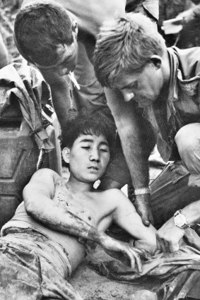 Major Geoff F. Cohen and Corporal D. F. Butler, both members of 3rd Battalion, The Royal Australian Regiment (3RAR), dress the wounds of a North Vietnamese soldier.