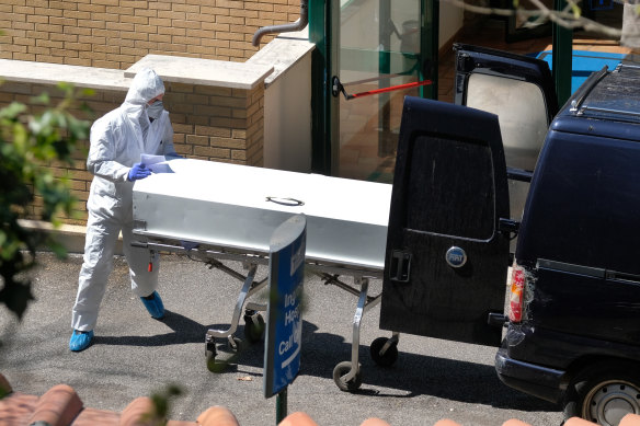 A coffin is carried out from the health care residence and hospice San Raffaele, that was cordoned off after some 80 people tested positive and two died, in Rocca di Papa, near Rome, on Wednesday.