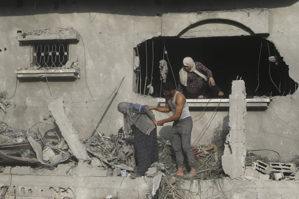Palestinians evacuate a building damaged in the Gaza Strip. 