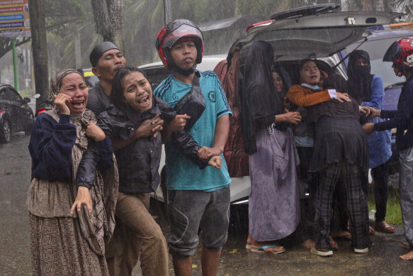 Families grieve as the body of a relative is recovered from the rubble. 