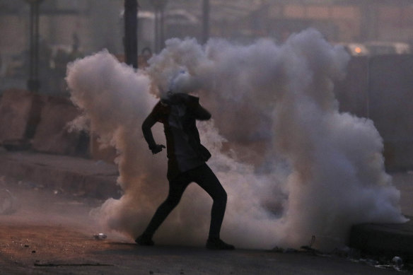 An anti-government protester finds himself in a cloud of tear gas during a demonstration in Baghdad. 
