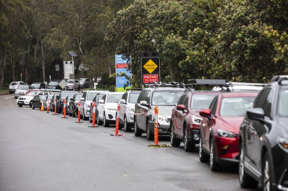 A long line of cars wait at the Mona Vale Hospital drive-through clinic on Monday morning. 