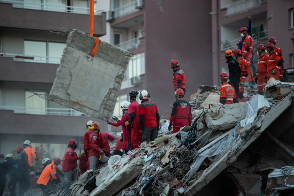 Emergency services personnel search a collapsed building for survivors after a powerful earthquake struck on October 31, 2020 in Izmir, Turkey. 
