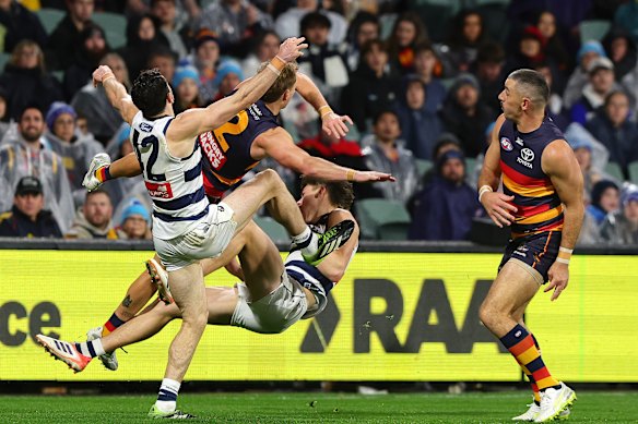 Cats and Crows players collide after Taylor Walker (right) pushes Connor O’Sullivan (bottom) into the pack.