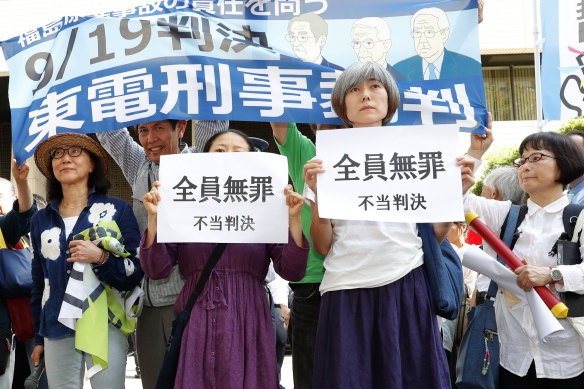 A group of demonstrators with banners reading "unjust sentence" stand in front of Tokyo District Court on Thursday.