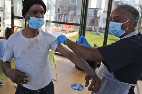 Dr Anil Mehta administers a dose of the AstraZeneca vaccine to a homeless person at the Welcome Centre in Ilford, east London.