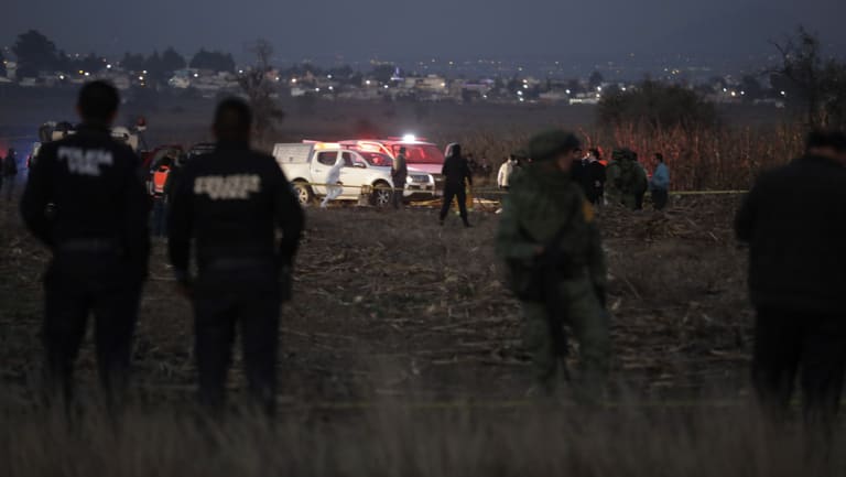 Rescue crews examine the scene of the helicopter crash near Puebla City.