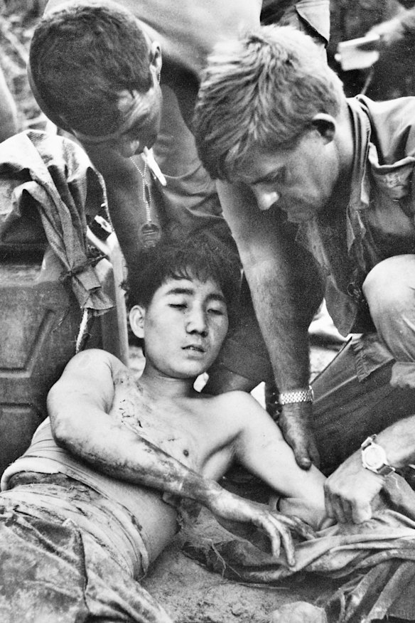 Major Geoff F. Cohen and Corporal D. F. Butler, both members of 3rd Battalion, The Royal Australian Regiment (3RAR), dress the wounds of a North Vietnamese soldier.