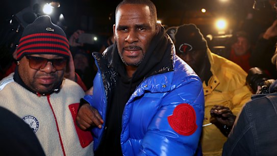 R. Kelly turns himself in at a Chicago police station after being charged with sexual abuse.