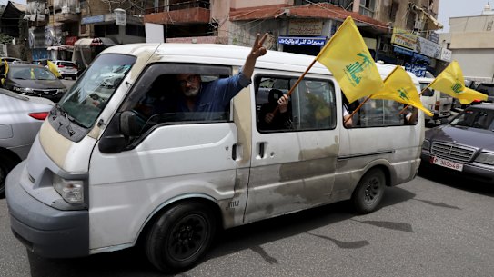Hezbollah supporters wave flags in Beirut. The organisation has lost its majority in the Lebanese parliament.