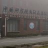 A security official moves journalists away from the Wuhan Institute of Virology in 2021.
