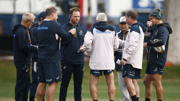 Brad Davis (left, with earpiece) is pictured in a Wallabies coaching huddle in Melbourne.