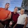 Photo of (L-R) Adrian Cropley, Jenny Holmes  and Ian Henson in front of their apartment at AC Marriott, Normanby Building in Southbank
