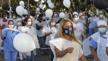 Health professionals hold balloons before releasing them to honour health workers who have died of COVID-19 outside Sao Paulo University Hospital.