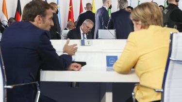 Australian PM Scott Morrison sits across the table as French President Emmanuel Macron chats with German Chancellor Angela Merkel at the G20 in Rome last month. 