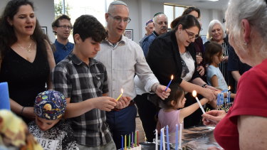 Rabbi Adi Cohen leads the chant as the Maces and other families light their prospective Chanukiahs on Shabbat day.