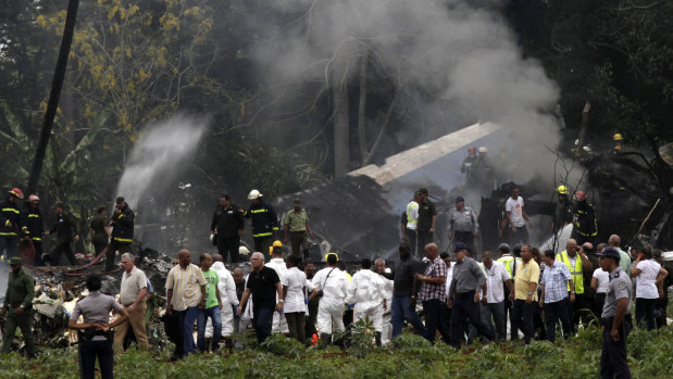 Cuban President Miguel Diaz-Canel, third from left, walks away from the site where a Boeing 737 plummeted into a yuca field with more than 100 passengers on board.