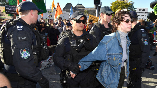 Police arresting an Extinction Rebellion protester after activists blocked the corner of Margaret and William streets in Brisbane on Tuesday.