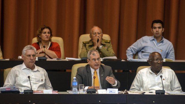 Cuban President Miguel Diaz-Canel, from left, Secretary, Council of State Homero Acosta Alvarez and First Vice President, Council of State Salvador Valdes Mesa, attend a National Assembly session in Havana, Cuba, on Saturday.