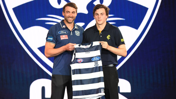 Cats champion Corey Enright hands Jordan Clark his first Cats jumper.