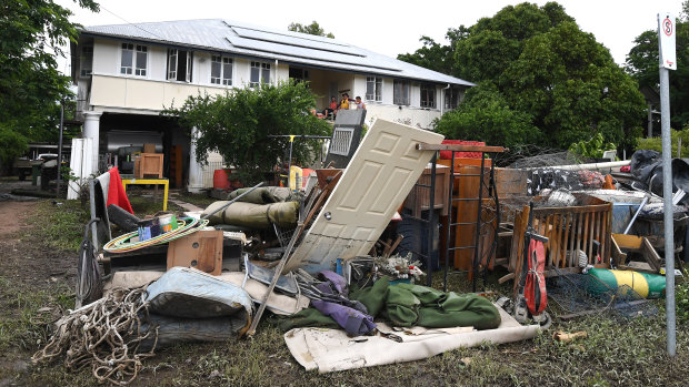 A large pile of water-damaged items in front of a flooded house in the Townsville suburb of Hermit Park on Wednesday.
