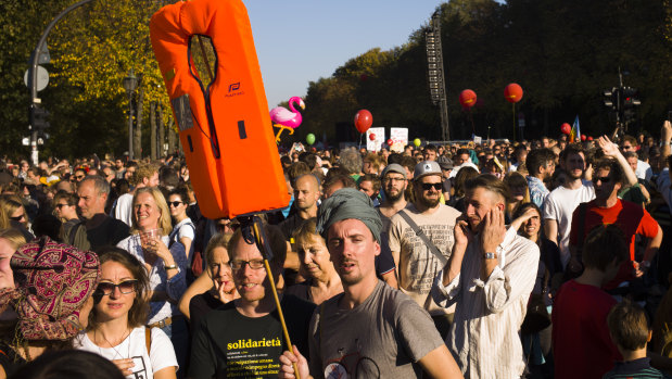 A man holds up a life jacket as he attends with thousands of protesters a demonstration with the slogan 'indivisible' and for solidarity instead of exclusion in Berlin, Germany on Saturday.