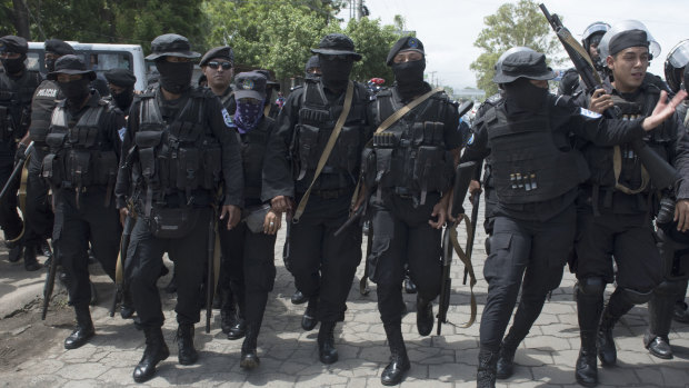 Armed police walk to break up an anti-government demonstration in Managua, Nicaragua.
