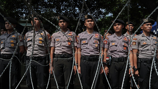 Members of the Indonesian National Police stand guard outside the General Elections Commission in Jakarta.