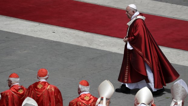 Pope Francis walks past cardinals after celebrating a Pentecost Mass in St Peter's Square at the Vatican.